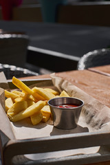 French fries and ketchup in basket with flare light