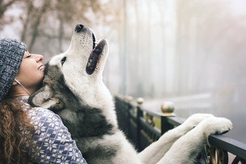 Image of young girl with her dog, alaskan malamute, outdoor