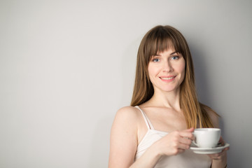 Obraz na płótnie Canvas young woman drinks coffee