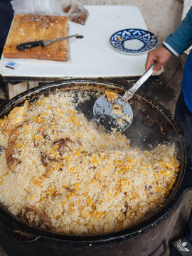 Crop person making national oriental dish