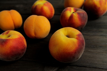 Ripe peaches on dark brown wooden surface