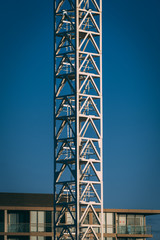 Crane Tower with apartment building in background and blue sky