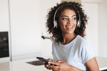 Delightened african woman in headphones