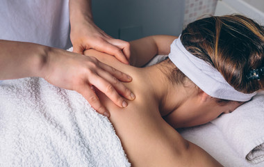 Obraz na płótnie Canvas Close up of young woman receiving a relaxing back massage on clinical center. Medicine, healthcare and beauty concept.