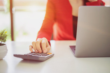 Woman working with calculator, business document and laptop computer notebook.