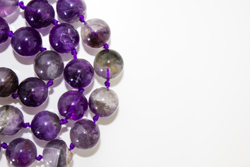 close up macro real nature purple amethyst beads (necklace) isolated on white