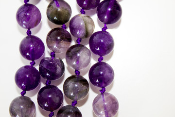 close up macro real nature purple amethyst beads (necklace) isolated on white