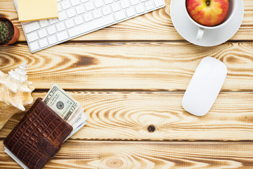 Outfit and accessories for travel. Camera, passports, wallet with money, sneakers and jeans on the wooden background. Laptop and notebook for planning. Travel, lifestyle, fashion and vacation concept