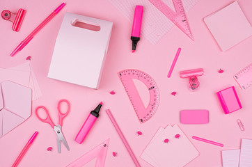 Pink office stationery collection on soft pastel pink paper background, top view.