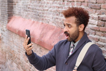 Male looking at phone with shocked expression 
