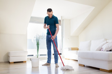household, housework and people concept - happy man with mop and bucket cleaning floor at home