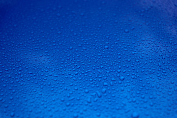 Rain drops on a blue smooth surface.