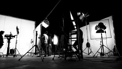 Behind the scenes of TV commercial movie film or video shooting production which crew team and camera man setting up green screen for chroma key technique in big studio. - obrazy, fototapety, plakaty