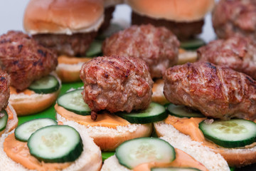 Homemade Hamburgers. Grilling Meatballs on Barbecue. Hamburgers and Buns.Outdoor picnic.
