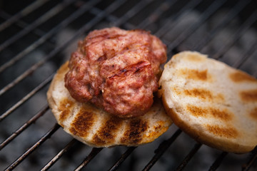 Burger and Buns Grilling on Fire. Homemade Hamburgers. Grill Meatballs. Making Hamburgers on a Grill. Outdoor Picnic. 
