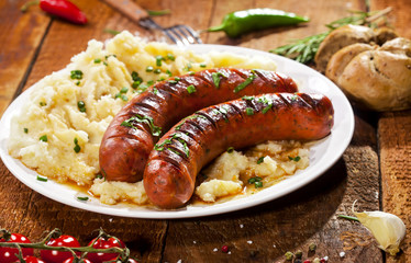 Grilled sausages and mashed potato on a white plate