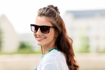 people, summer and eyewear - happy smiling young woman in sunglasses outdoors