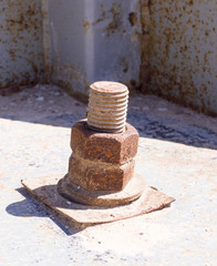 rusty iron screw with nut at sunny day. industrial concept