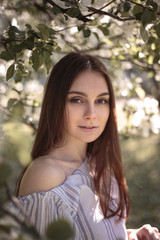 Fototapeta premium Pretty young woman in a summer garden, casual romantic style with hat