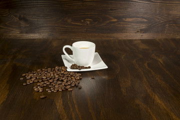Kaffeetasse mit Kaffeebohnen auf Holzhintergrund