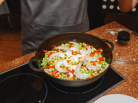Cooking of a paella in pan in a kitchen