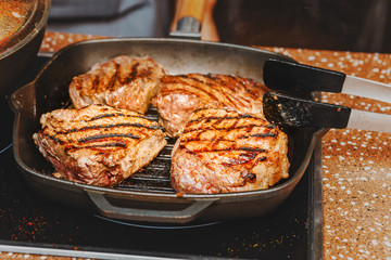 cooking delicious beef steak on a grill pan with lots of smoke
