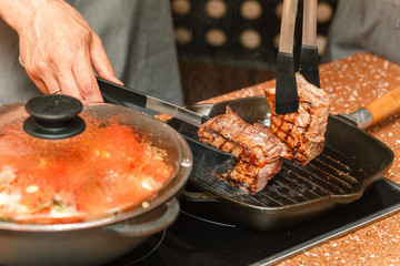 cooking delicious beef steak on a grill pan with lots of smoke