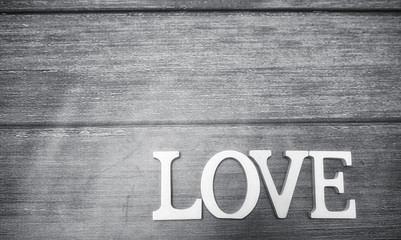 word love made up of white wooden letters on a wooden background
