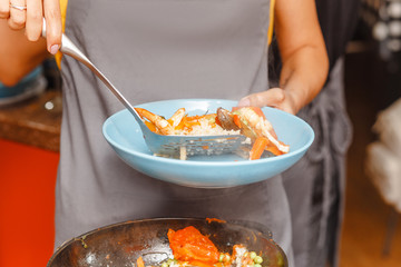 Cooking spanish paella at home or at restaurant