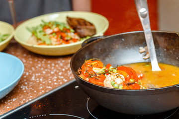 Cooking spanish paella at home or at restaurant