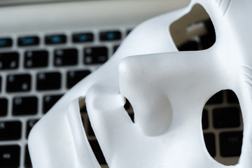Identity on Social Networks concept  White mask on gray laptop
