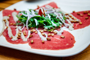 Fresh Sliced raw beef meat with leaf lettuce on the table