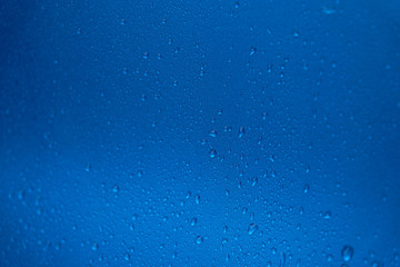 Rain drops on a blue smooth surface.