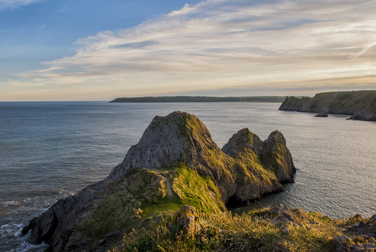 Landscape image of Three Cliffs Bay at sunset 