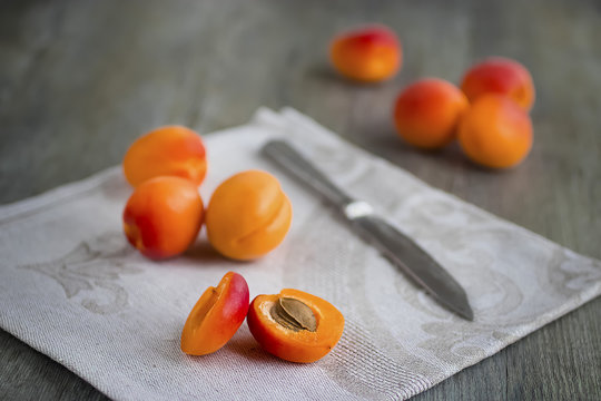 Ripe bright apricots,  knife and gray napkin. Gray  background.