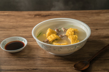 Corn bone soup, wood grain background