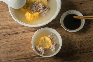 Corn bone soup, wood grain background
