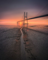Fototapeta na wymiar Mystical dawn, Sunrise and the bridge on a foggy day