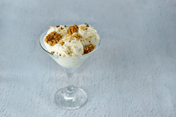 Ice cream in a glass bowl with walnuts and meringue