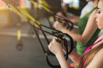 Woman performing suspension training in gym