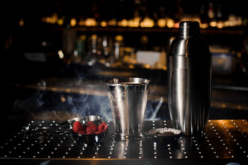 Steel shaker, tweezzers, cup and saucer with raspberry