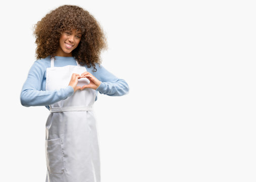 African american shop owner woman wearing an apron happy showing love with hands in heart shape expressing healthy and marriage symbol