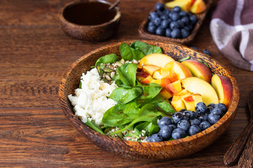 Summer spinach and fruit salad with seeds, mozzarella and balsamic vinegar in a bowl. Summer food concept