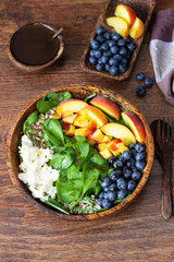Summer spinach and fruit salad with seeds, mozzarella and balsamic vinegar in a bowl. Summer food concept