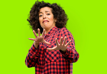 Beautiful arab woman disgusted and angry, keeping hands in stop gesture, as a defense, shouting