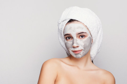 Beautiful Girl With Applied Clay Mask At Grey Background