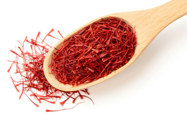 saffron thread in the wooden spoon, isolated on white background, top view