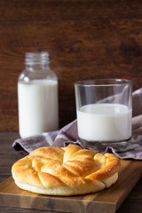 Fresh tasty bread with milk bottle on the wooden table.