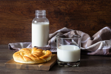 Fresh tasty bread with milk bottle on the wooden table.