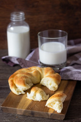 Fresh tasty bread with milk bottle on the wooden table.